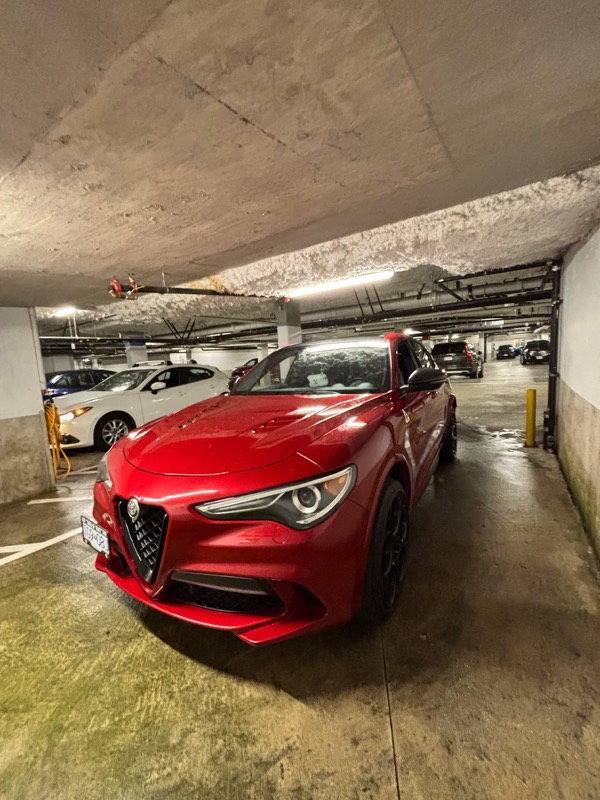 Red Alfa Romeo Stelvio in an underground parkade