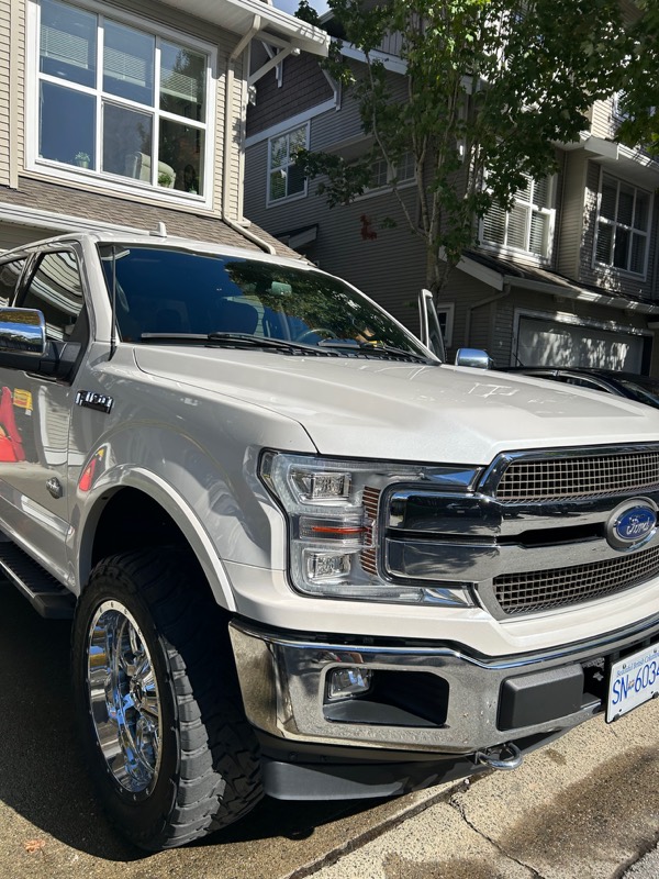 White Ford F-150 side profile after a wash