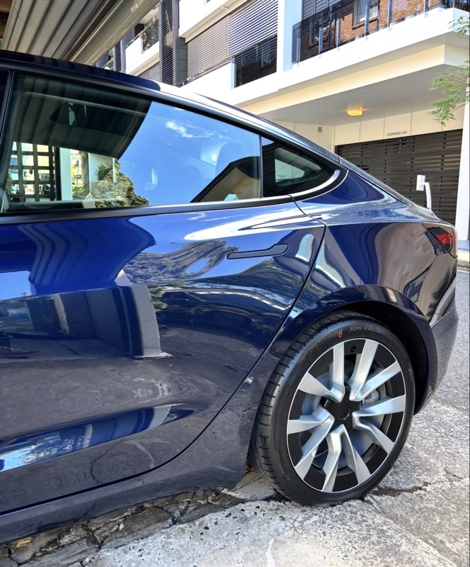 Deep blue Tesla paint with sharp, glossy reflections