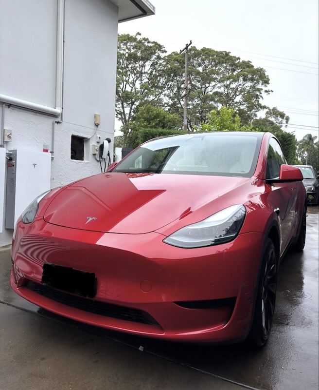 Red Tesla Model Y with a fresh, glossy finish
